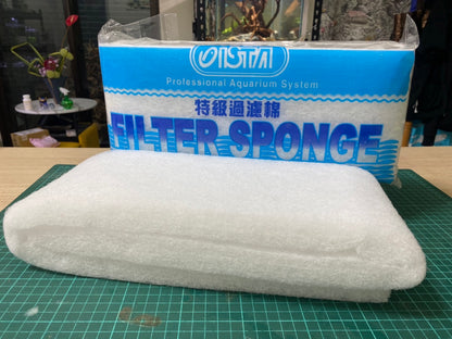 a white bed with a blue pillow on it 